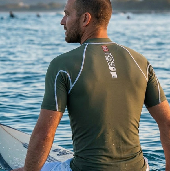 Homme en t-shirt anti-UV pratiquant le kitesurf.